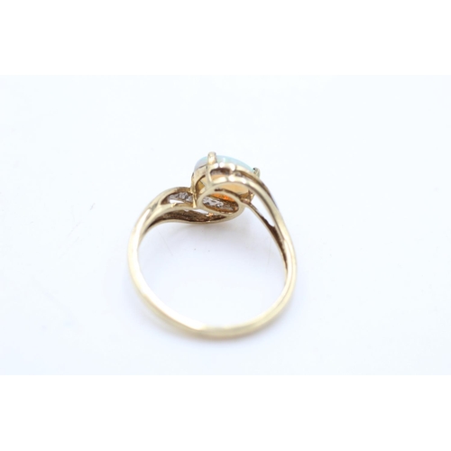 74 - A 9ct gold opal and diamond bypass ring, size S - approx. gross weight 2.7 grams