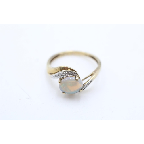 74 - A 9ct gold opal and diamond bypass ring, size S - approx. gross weight 2.7 grams