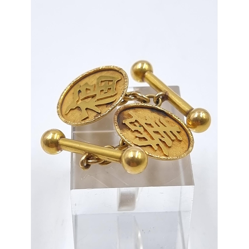 181 - A pair of oriental yellow metal cufflinks, stamped 'AT 18' - approx. gross weight 6.92 grams