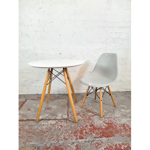 1119 - A contemporary Eames style white laminate and beech circular dining table with grey plastic dining c... 