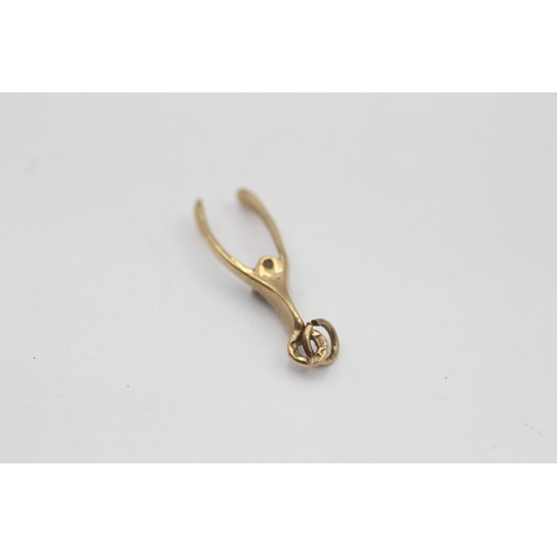 1 - A 9ct gold diamond set wishbone pendant - approx. gross weight 0.7 grams