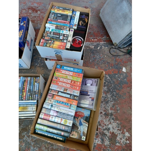 1444 - Four boxes containing DVDs and VHS videos - see images for titles