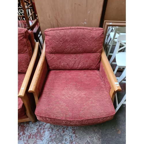 182 - An Ercol ash framed and red upholstered three piece lounge suite comprising three seater sofa, two s... 