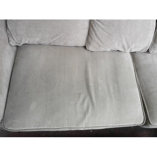 238 - A modern beige upholstered three seater sofa with two matching foot stools - approx. 88cm high x 295... 