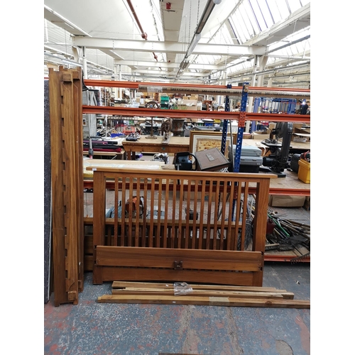 244 - An Indonesian solid teak bedframe - top of the headboard measures approx. 183cm