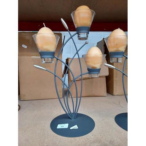 418 - A pair of grey metal candle holders, each with three egg shaped candles