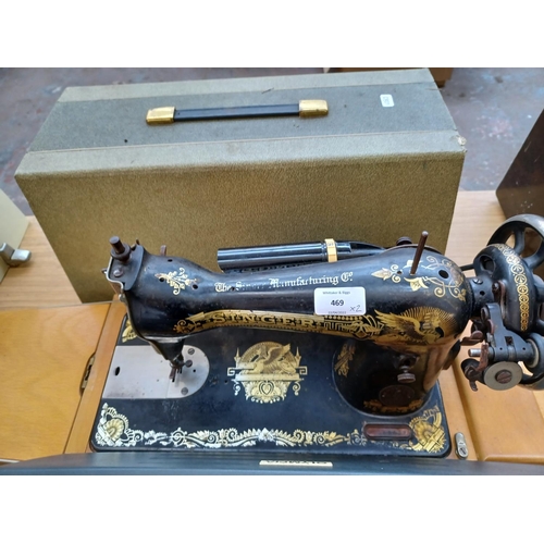 469 - Two items, one cased Singer electric sewing machine with light and one Olympia typewriter