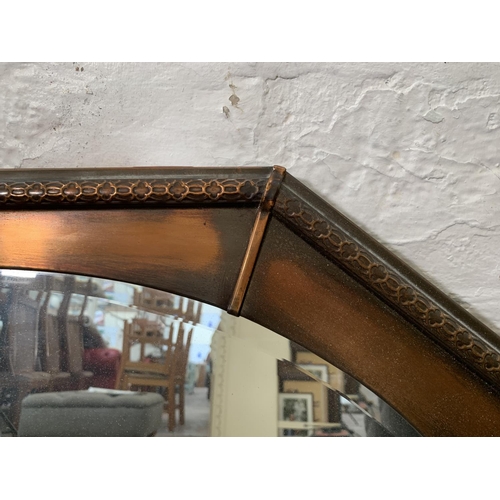 258 - An Arts & Crafts style copper framed oval bevelled edge wall mirror - approx. 63cm high x 82cm wide