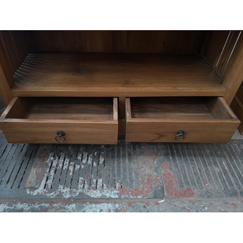 117 - An Indonesian solid teak five tier free standing bookcase with two lower drawers - approx. 192cm hig... 