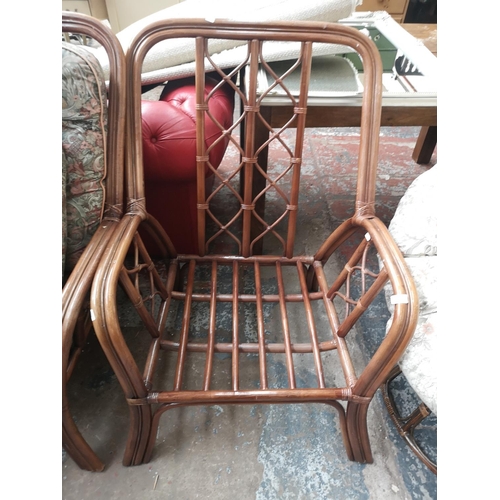 119 - A bamboo four piece conservatory suite comprising two seater sofa, two armchairs and circular side t... 