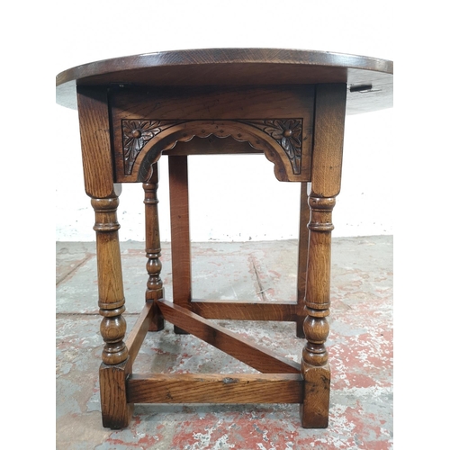 132 - An 18th century style carved oak drop leaf gateleg circular occasional table - approx. 58cm high x 6... 