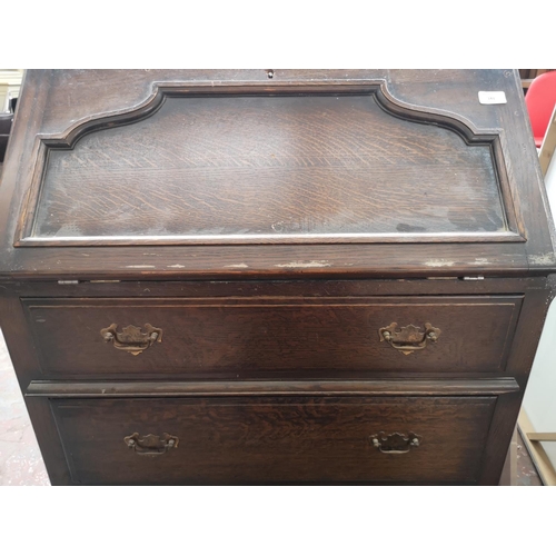 143 - A mid 20th century oak bureau with three drawers and fall front - approx. 100cm high x 76cm wide x 4... 