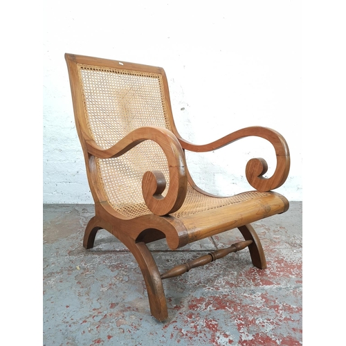 146 - An Indian sheesham wood and rattan plantation chair with matching foot stool - chair approx. 106cm h... 