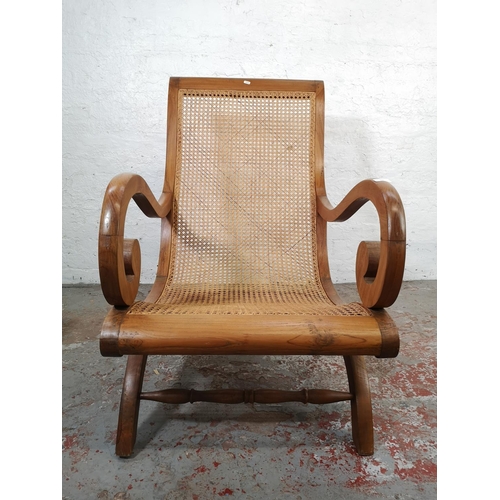 146 - An Indian sheesham wood and rattan plantation chair with matching foot stool - chair approx. 106cm h... 