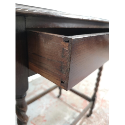 163 - A mid 20th century oak rectangular side table with barley twist supports and later added castors - a... 