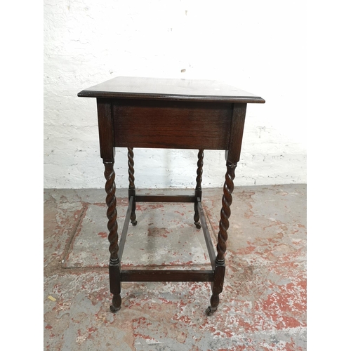 163 - A mid 20th century oak rectangular side table with barley twist supports and later added castors - a... 