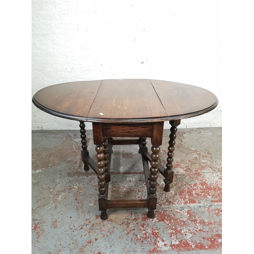 165 - A mid 20th century oak drop leaf gateleg oval dining table with barley twist supports - approx. 74cm... 