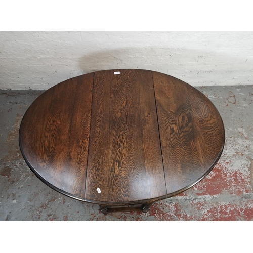 165 - A mid 20th century oak drop leaf gateleg oval dining table with barley twist supports - approx. 74cm... 