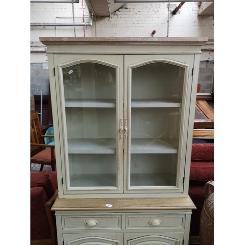 169 - A French style white painted and limed oak dresser with two glazed doors, two drawers and two lower ... 