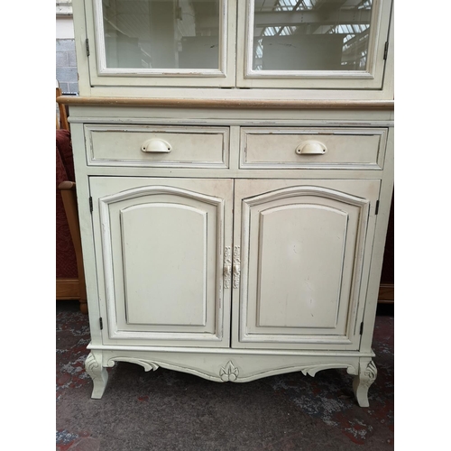 169 - A French style white painted and limed oak dresser with two glazed doors, two drawers and two lower ... 