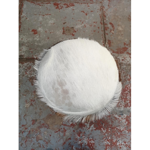 194 - A goat hide circular stool with wooden supports - approx. 43cm high x 30cm diameter