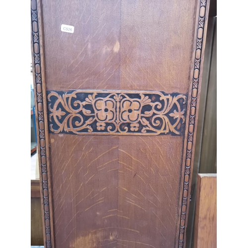 199 - An early 20th century carved oak wardrobe with central bevelled edge mirror door - approx. 192cm hig... 