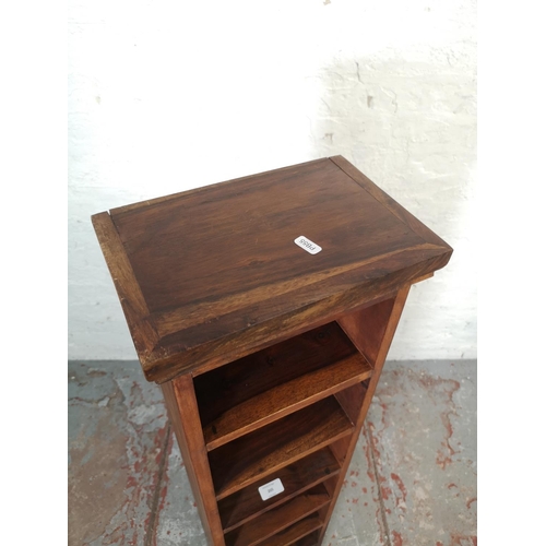 205 - An Indian sheesham wood eight tier freestanding CD rack - approx. 123cm high x 28.5cm wide x 19cm de... 