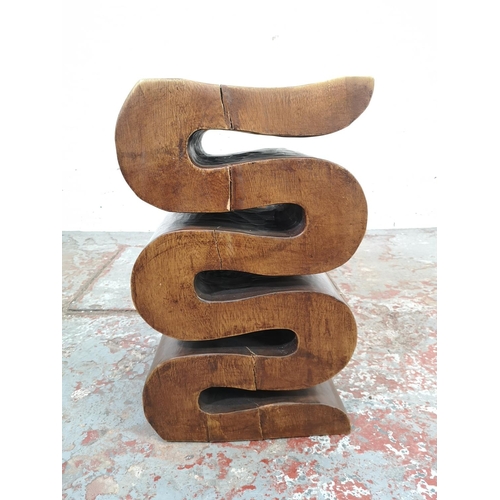 206 - A contemporary carved hardwood snake design side table - approx. 51cm high x 30cm wide x 29.5cm deep