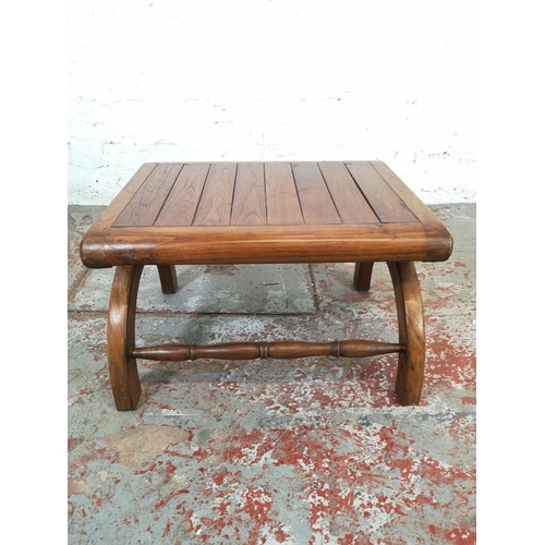 211 - An Indonesian solid teak plantation chair with matching stool - approx. 110cm high x 64cm wide x 76c... 