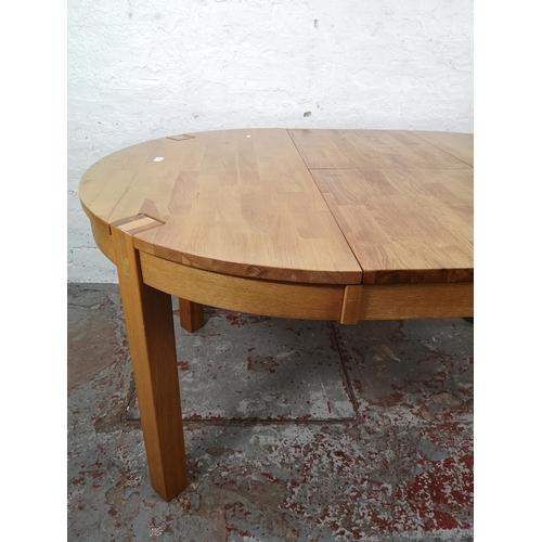 27 - A modern solid oak circular extending dining table - approx. 75cm high x 110cm diameter