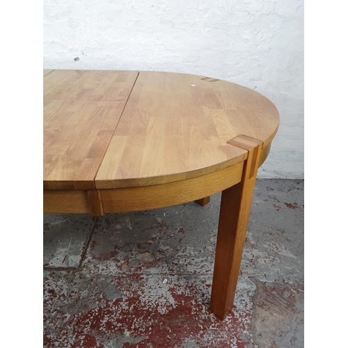 27 - A modern solid oak circular extending dining table - approx. 75cm high x 110cm diameter