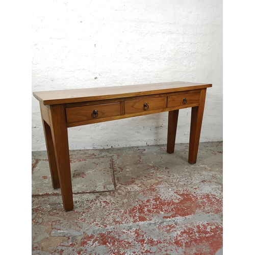 31 - An Indonesian teak three drawer console table - approx. 75cm high x 135cm wide x 40cm deep