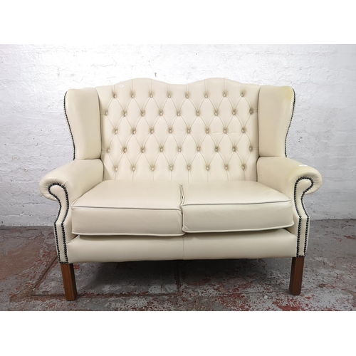 37 - A Chesterfield style white leatherette two seater wing back sofa - approx. 105cm high x 25cm wide x ... 