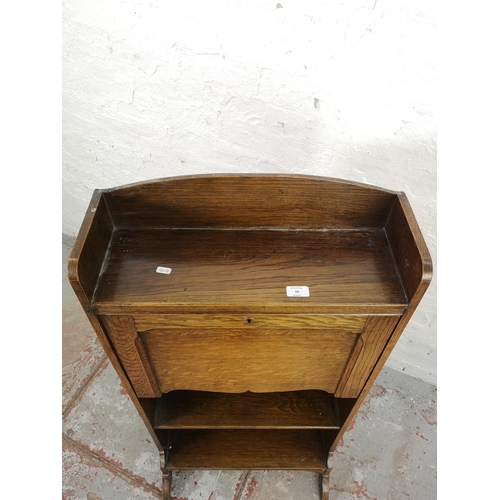 54 - An early/mid 20th century oak bureau with fall front and two lower shelves - approx. 118cm high x 56... 