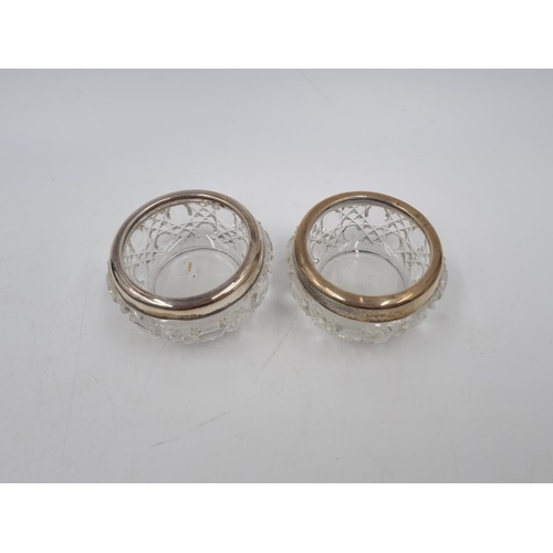 1042 - A boxed pair of cut glass salts with hallmarked Chester silver collars and two spoons, dated 1911