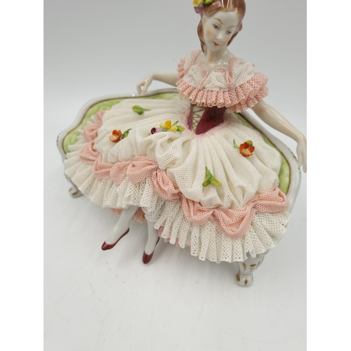 1140 - A Volkstedt porcelain lace figurine of lady on bench - approx. 14cm high x 18cm wide