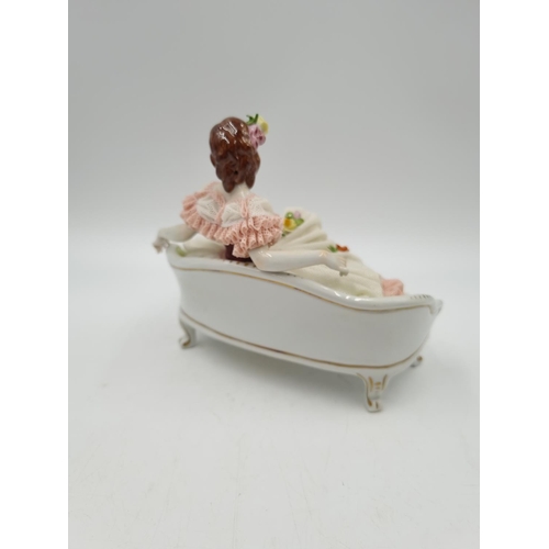 1140 - A Volkstedt porcelain lace figurine of lady on bench - approx. 14cm high x 18cm wide