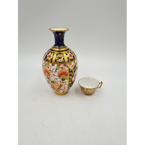 1153 - Two pieces of Royal Crown Derby Old Imari china comprising 11.5cm bud vase and miniature tea cup