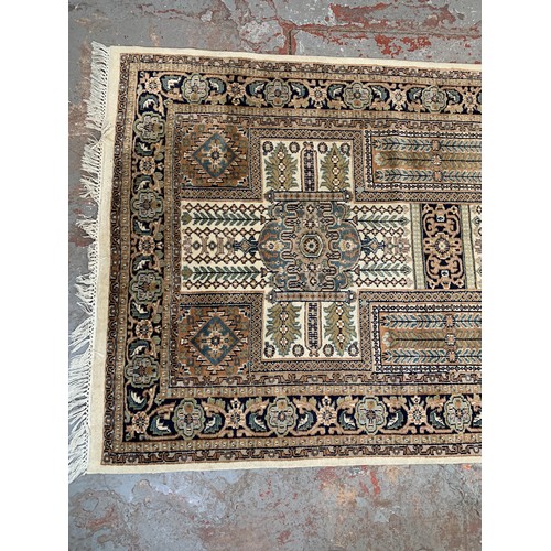 248A - A Persian style brown and cream rug - approx. 215cm x 126cm