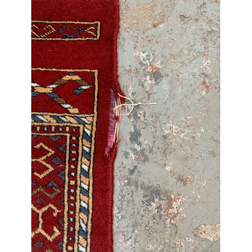 249 - A Persian style red rug - approx. 200cm x 120cm