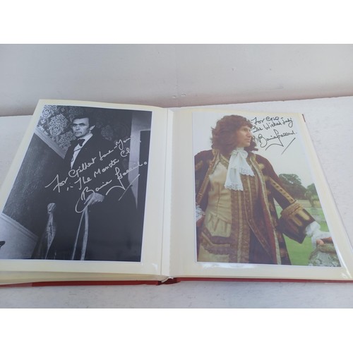 396 - A photo album containing signed film photographs.