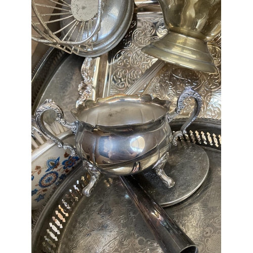 533 - A box containing assorted silver plated ware to include candlestick holders, serving trays, twin han... 