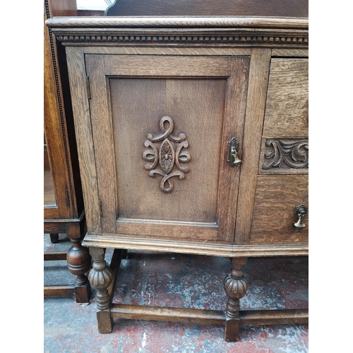 53 - An early 20th century carved oak sideboard with two central drawers, two outer cupboard doors and ba... 