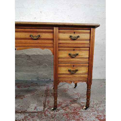 113 - A late Victorian Aesthetic Movement oak writing desk with green leather insert and castors - approx.... 