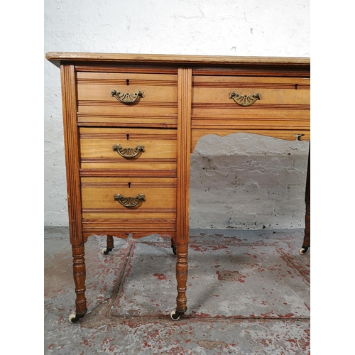 113 - A late Victorian Aesthetic Movement oak writing desk with green leather insert and castors - approx.... 