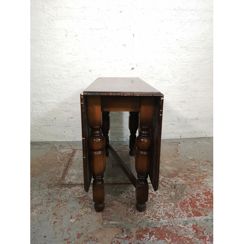 124 - An oak drop leaf gate leg dining table and four matching chairs - approx. 72cm high x 90cm wide x 14... 