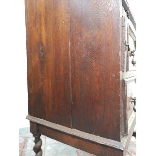 130 - An early 20th century Jacobean style geometric carved oak bureau with two drawers and fall front - a... 