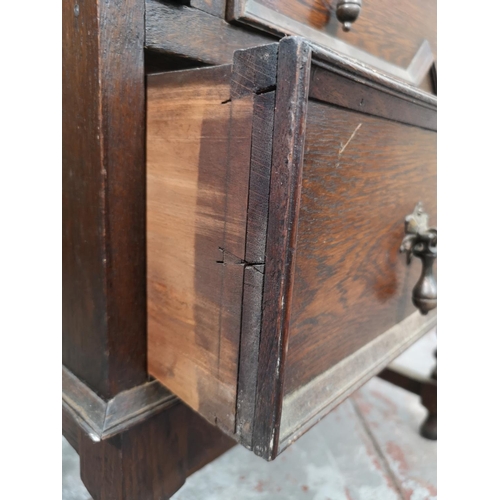 130 - An early 20th century Jacobean style geometric carved oak bureau with two drawers and fall front - a... 