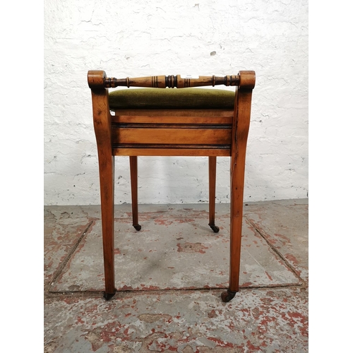 144 - An Edwardian beech twin handled piano stool with green upholstered lid