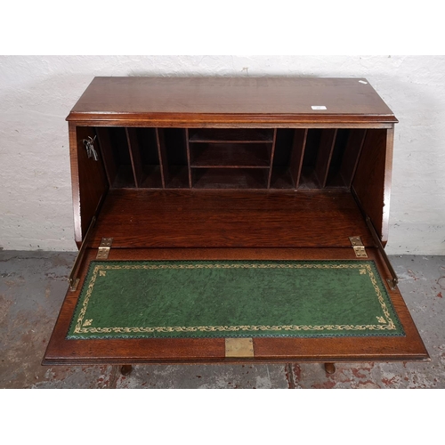 155 - A mid/late 20th century oak bureau with three drawers, fall front and cabriole supports - approx. 10... 